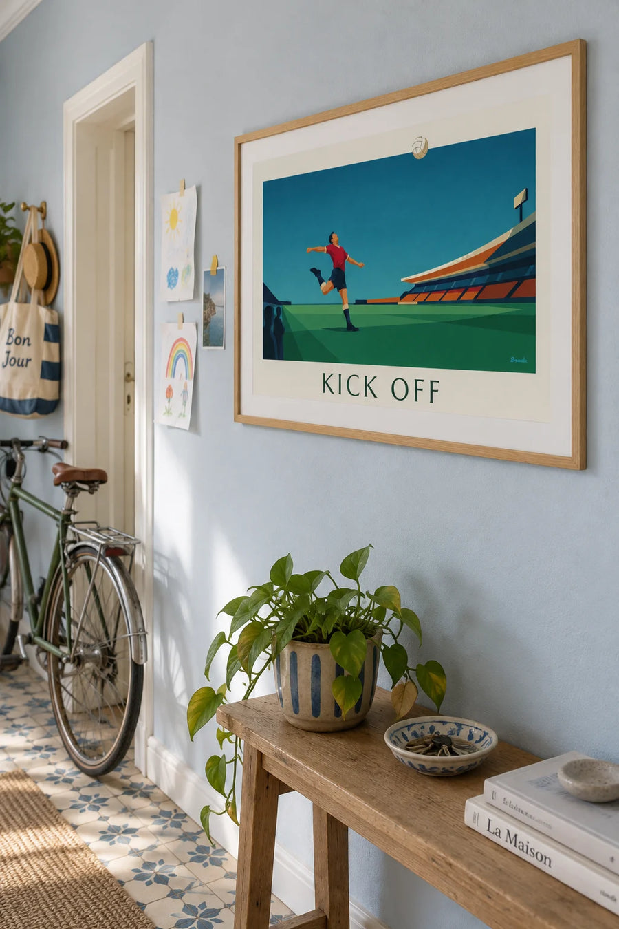 Poster of a soccer player kicking the ball in a stadium: framed on the wall