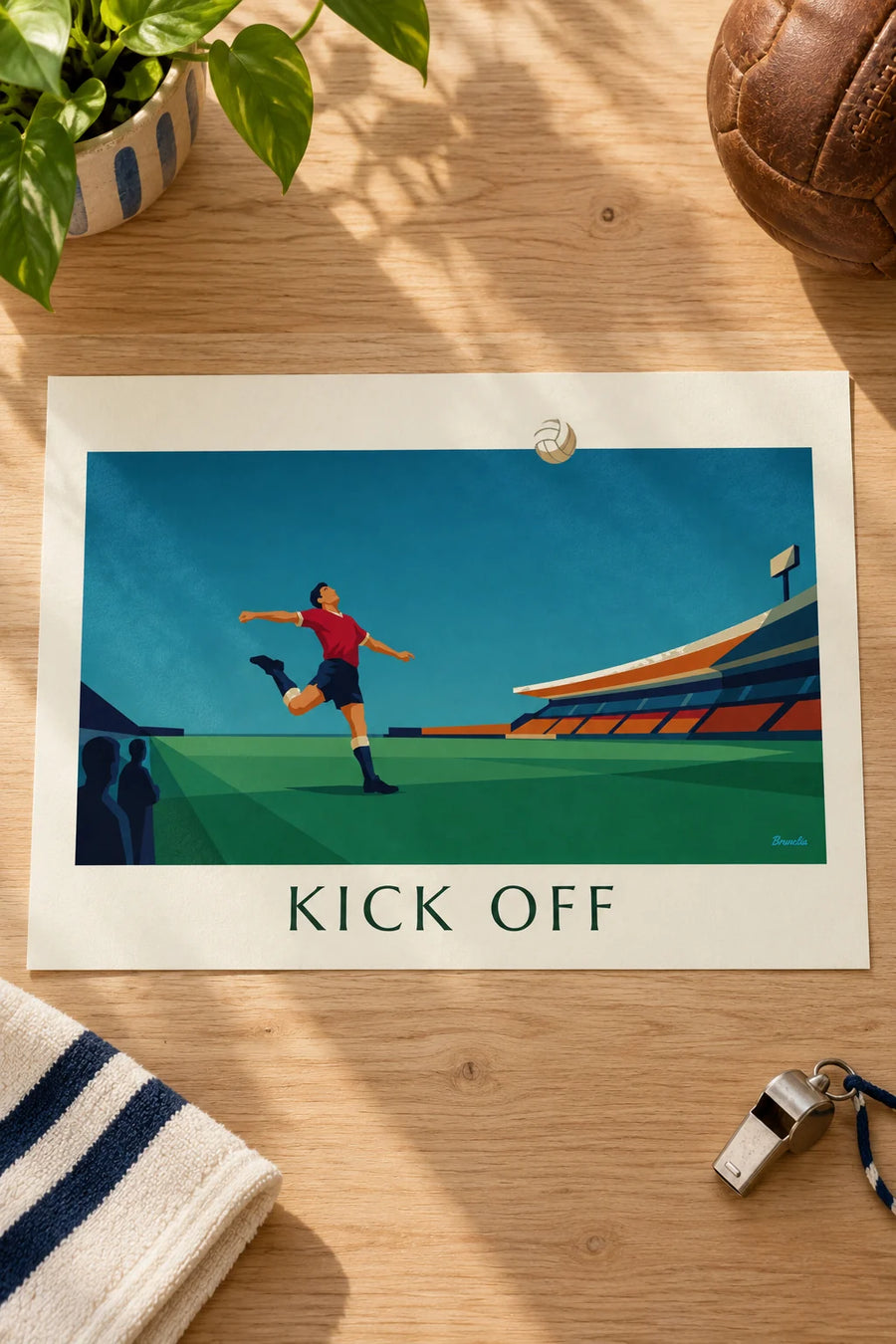 Poster of a soccer player kicking the ball in a stadium: resting on a table
