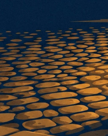 Cobbles with ochre and golden reflections in the street at night