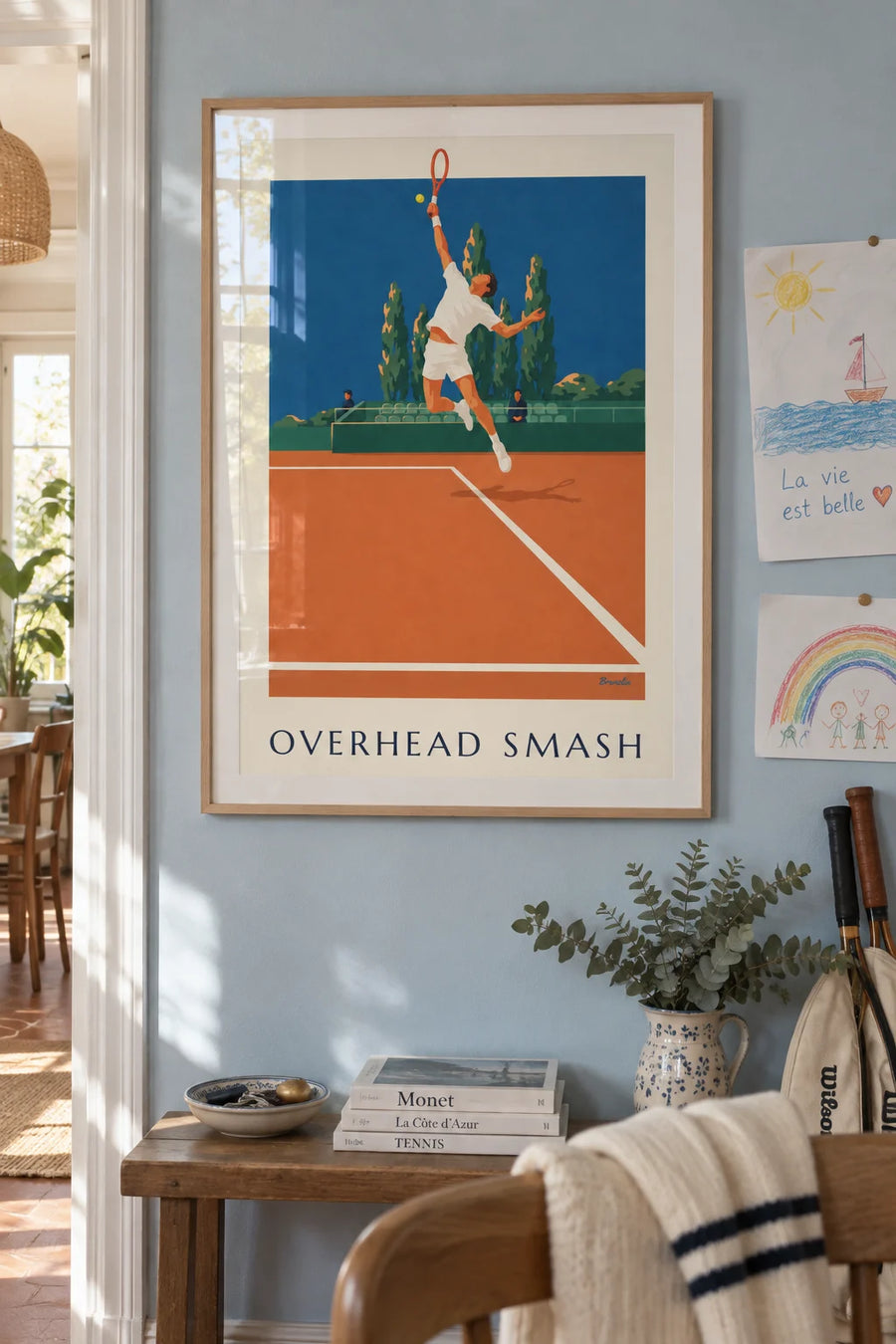 Poster of a tennis player mid-smash on a clay court: framed on the wall