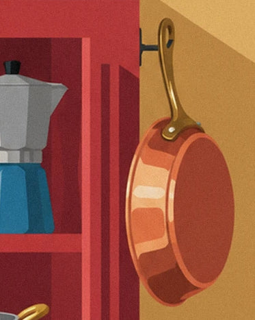 Une poêle en cuivre au manche doré, suspendue près du buffet rouge et de la cafetière