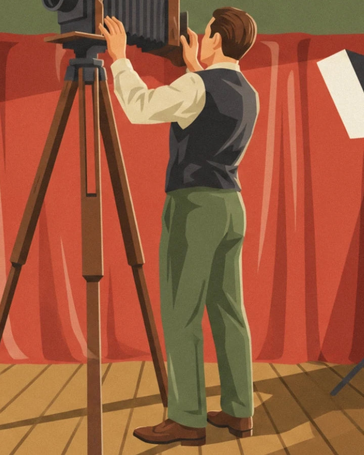 The photographer in a dark waistcoat and green trousers in front of his bellows camera on a tripod