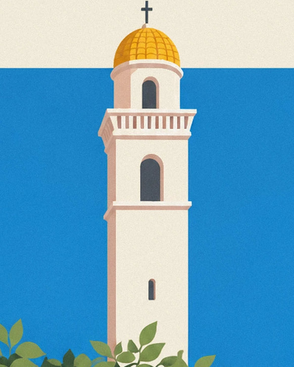 The white bell tower with a yellow dome topped by a cross in front of the blue sea