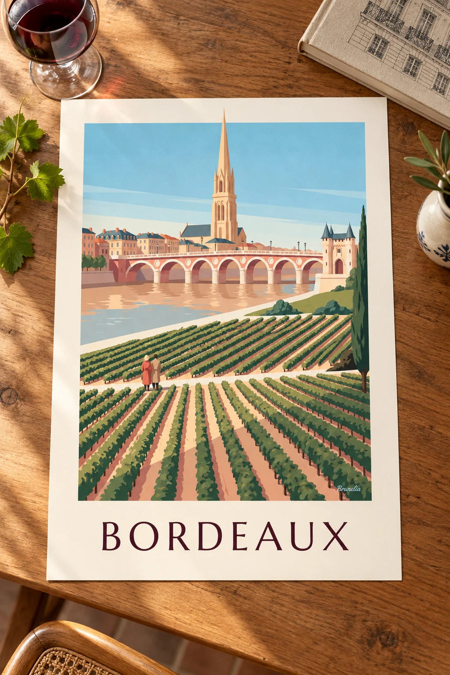 Affiche pont de pierre et porte Cailhau à Bordeaux vus des vignes : posée sur une table