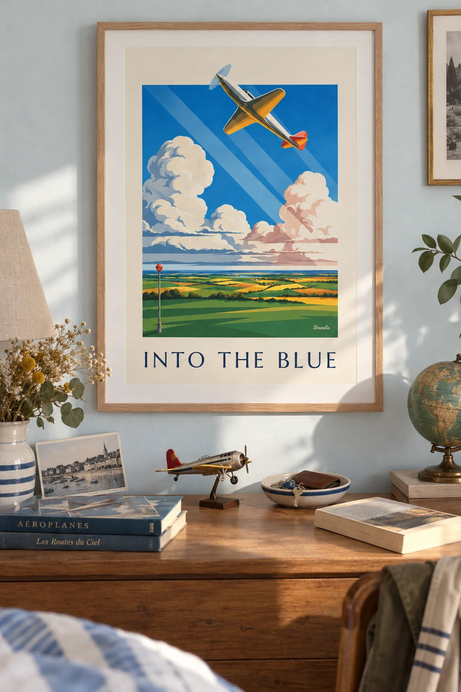 Poster of a propeller plane among the clouds above the fields: framed on the wall